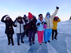 Group of happy tourists walking against Baikal wind