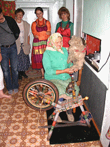 Old woman weaving using old weaving loom